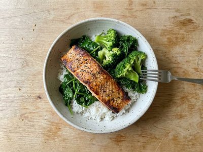 A bowl of salmon, rice and greens