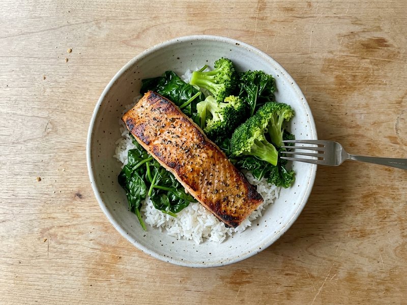 A bowl of salmon, rice and greens